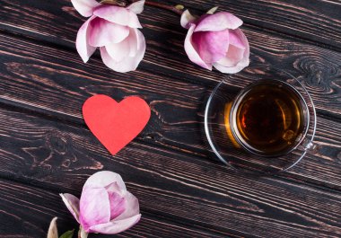 Fincan siyah çay ve çiçek Manolya ahşap kurullarında.