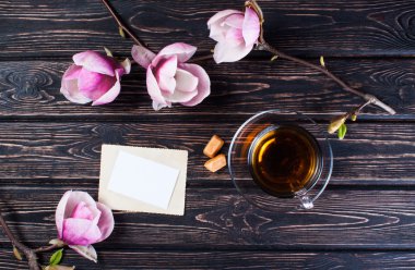 Fincan siyah çay ve çiçek Manolya ahşap kurullarında.