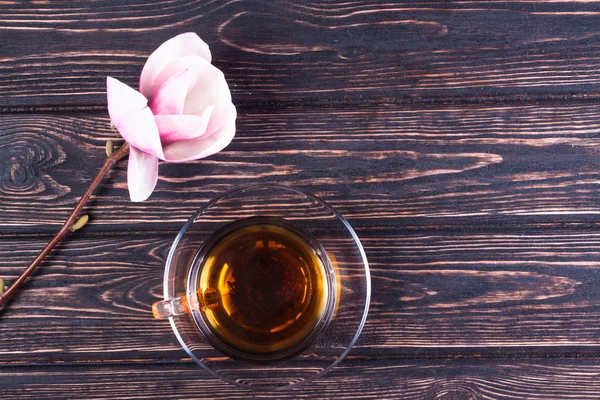 Fincan siyah çay ve çiçek Manolya ahşap kurullarında.