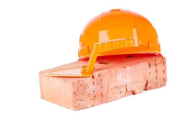 Capacete de construção laranja com tijolo — Fotografia de Stock