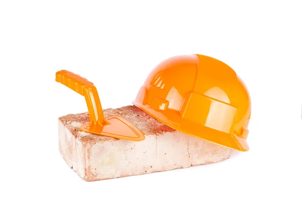 Capacete de construção laranja com tijolo — Fotografia de Stock