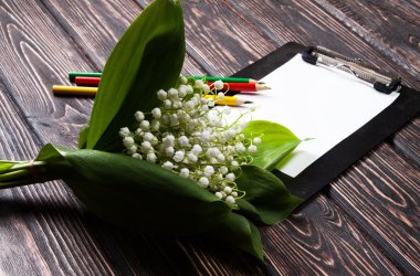 Eski ahşap masaya vadideki zambak çiçek ile güzel çerçeve çiçek.