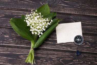 Eski ahşap masaya vadideki zambak çiçek ile güzel çerçeve çiçek.