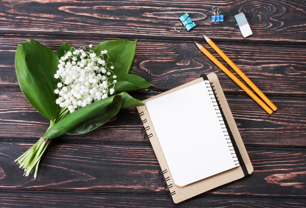 Bela moldura floral com lírios das flores do vale na mesa de madeira velha . — Fotografia de Stock