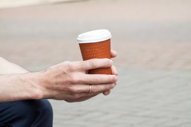 Elinde tek kullanımlık Kupası.