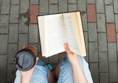 Adam sokakta bir kitap okuma. 