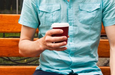 Elinde tek kullanımlık Kupası.