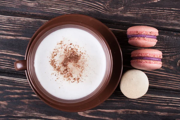 Cup of coffee and macaroon on the boards.