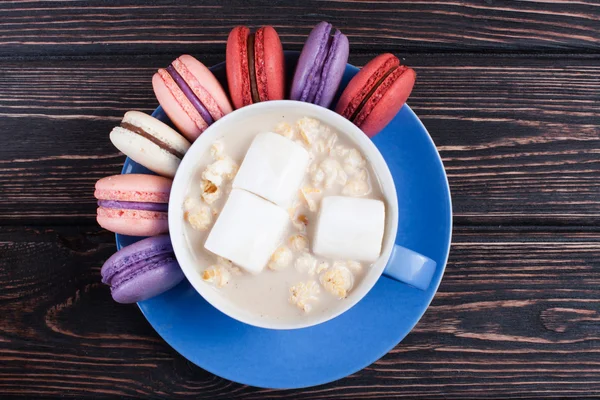 Cup of coffee and macaroon on the boards.