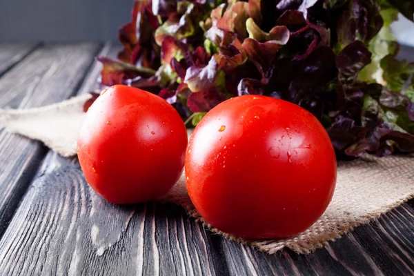 Lechuga con tomate en escritorio de madera — Foto de Stock