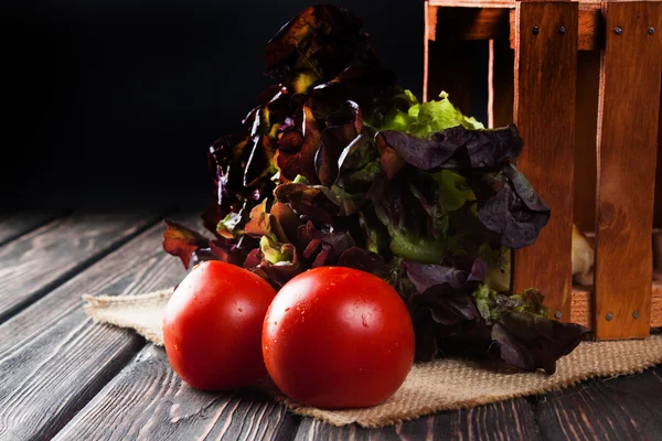 Lechuga con tomate en escritorio de madera — Foto de Stock