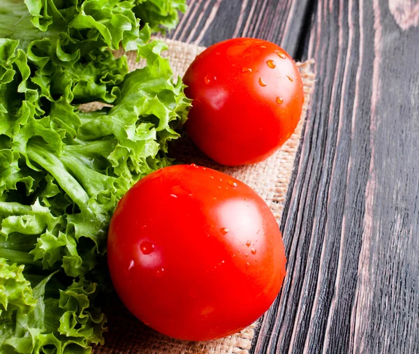 Sallad med tomat på trä skrivbord — Stockfoto