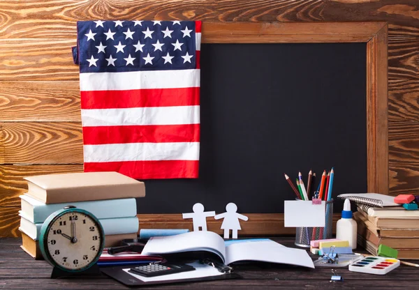 Tablero escolar y papelería en mesa de madera . — Foto de Stock