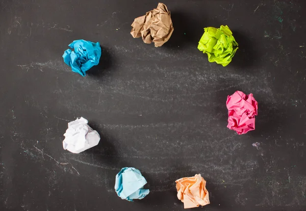 Gekleurde verfrommeld papier op een schoolbord. — Stockfoto