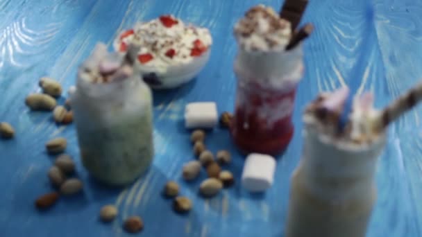 Potten met fruit cocktails op een blauwe schijf. — Stockvideo