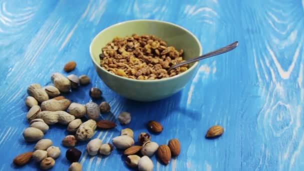 Chocolate flakes in a green bowl and different types of nuts. — Stock Video