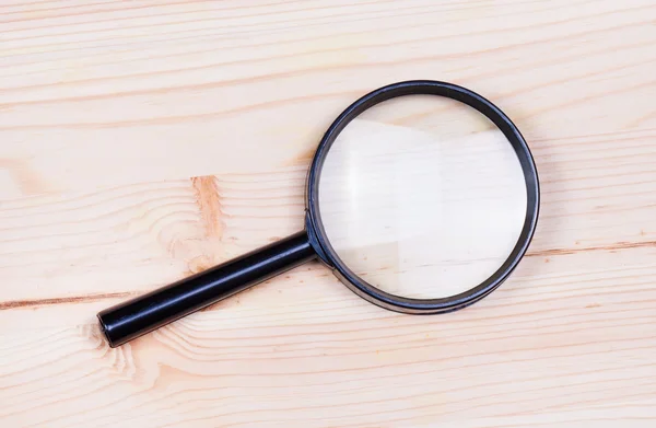 Lupa sobre fondo de madera — Foto de Stock