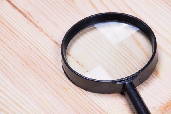 Lupa sobre fondo de madera , — Foto de Stock