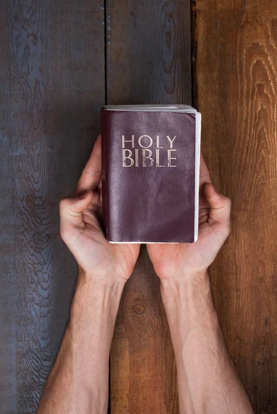 De bijbel boven tafel houden — Stockfoto