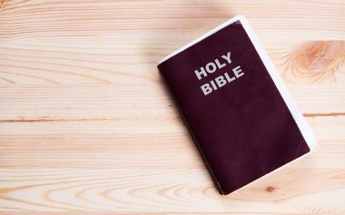 Holy Bible on old wooden church table clipart