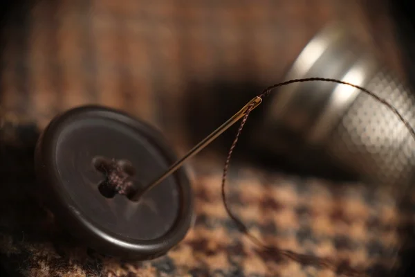 Кнопка для шитья на твидовом пальто — стоковое фото