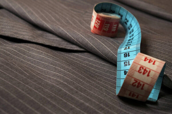 Classic striped gray suit coat and measure tape being unrolled
