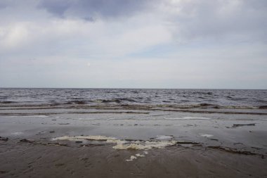 Bulutlu bahar gününde beyaz deniz plajı