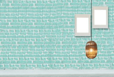 yeşil dekoratif tuğla duvar, boş çerçeve, modern lamba ve iç tasarım
