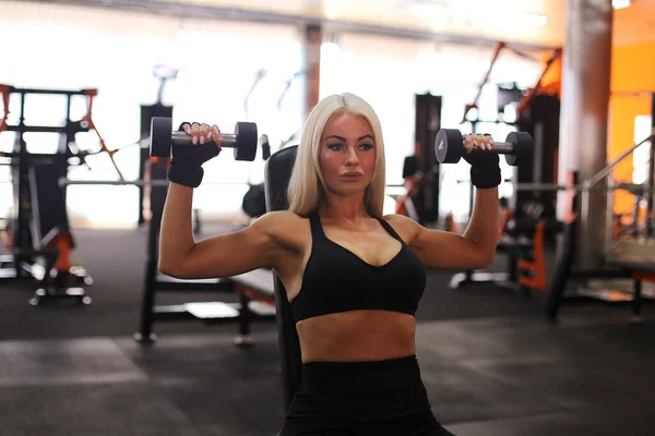 Attractive blonde portrait over orange gym background