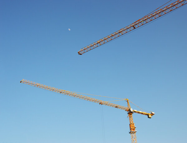 High-rise construction cranes against the sky