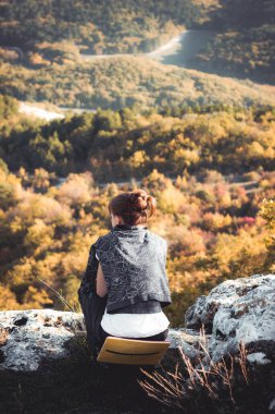 Kız dağın tepesinde meditasyon yapıyor.