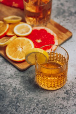 Limonlu ve greyfurtlu viski bardağında turunç kokteyli.
