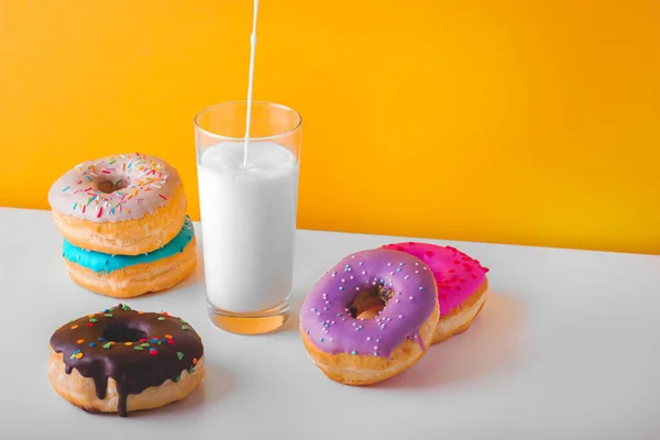 Sweet donuts with a glass of pouring plant milk