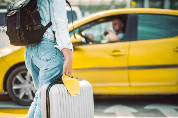 Frau wartet mit Mundschutz und Reisetasche auf Taxi — Stockfoto