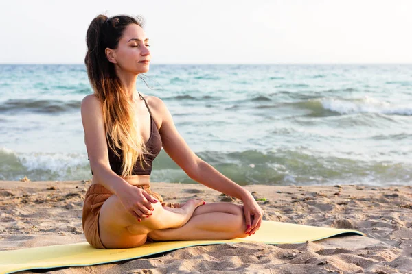 Beautiful woman practicing yoga at the beach — Stock Photo, Image