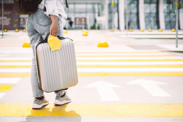 Frau überquert Straße mit Koffer und Mundschutz — Stockfoto