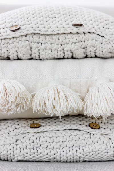 Un tas d'oreillers tricotés texturés avec boutons et glands Images De Stock Libres De Droits