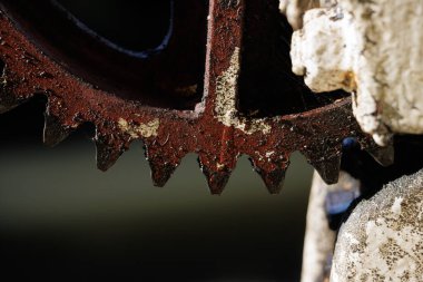 Taş duvardaki eski, yağlı metal dişli.