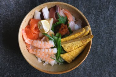 Japon chirashi suşi kasesi pişmiş karides, yumurta, çiğ somon, ahtapot ve pirinç üzerine ton balığı.