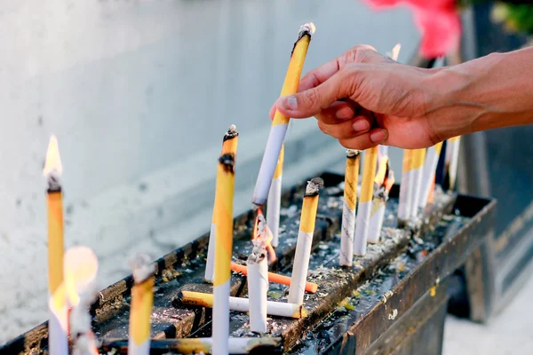 Man lighting prayer candle aka offering blur and soft focus — Stock Photo, Image