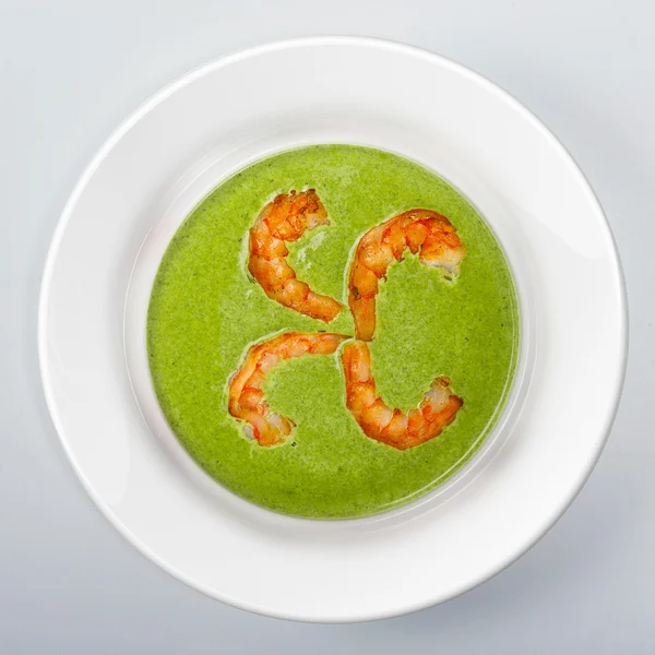 Spinatsuppe mit Garnelen auf weißem runden Teller — Stockfoto