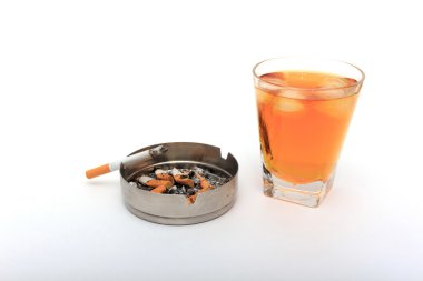 Bardak buzlu viski. Bir kül tablası ve üzerinde bir sigara bir