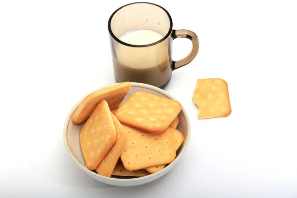 Crackers avec un verre de lait sur fond blanc — Photo