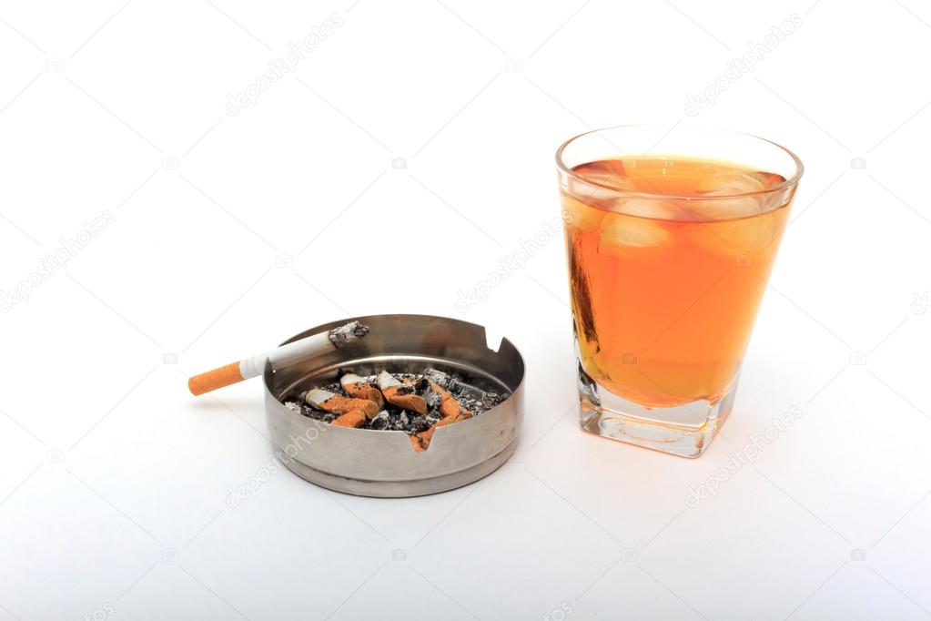 Glass of whiskey with ice. With an ashtray and a cigarette on a