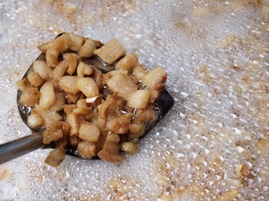 Tavada kızartılmış domuz eti. Büyük bir tavada kızartılmış küçük domuz parçalarıyla bir sürü baloncuk. Dikkatlice odaklan ve konuyu seç..