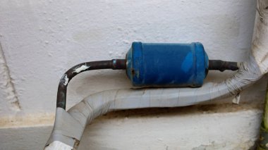 Kirli kuru filtre. Soğutma veya havalandırma sisteminde metal silindir ve mavi yalıtım tüpü. Fotokopi alanı olan beyaz bir arka planda. Dikkatlice odaklan ve konuyu seç..
