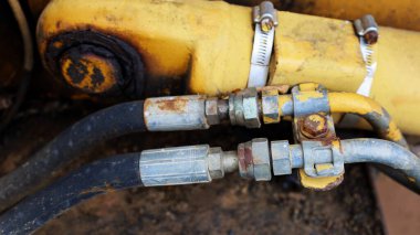 Eski metal hortumlar. Hidrolik sistem kıskaçlarında çift paslı eklemler eski hidrolik hortumları ağır makine ekipmanlarına bağlıyor. Odaklan ve bir nesne seç