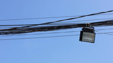 Işıklar siyah bir kabloda asılı. Fotokopi alanı olan mavi bir gökyüzü arka planında. Odaklan ve bir nesne seç