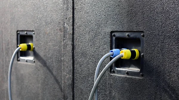 Arkasında hoparlör ve kablolar var. Amplifikatör ve hoparlörleri bağlamak için arkasında kablolar olan büyük açık hava siyah hoparlörleri. Seçici odak