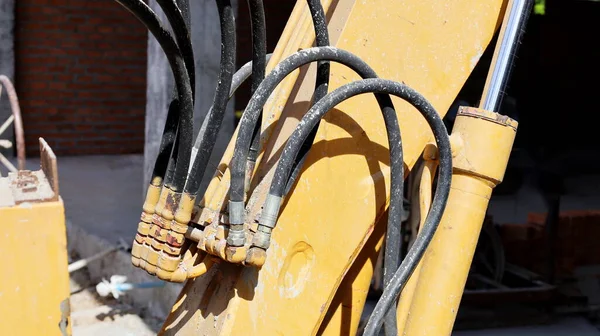 Eski kazıcı kolundaki hidrolik borular ve hortumlar. İnşaat alanındaki sarı ağır makinenin hidrolik sisteminde fotokopi alanı var. Seçici odak